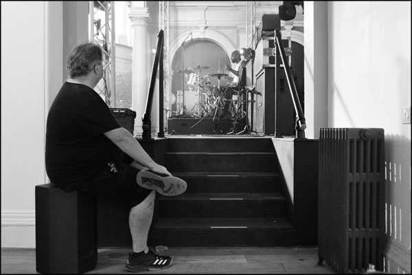 A stage tech watches the drummer from Feral Sun, Hammerdown Festival 2022, by Greig Clifford
