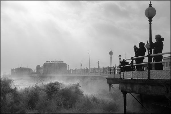 B-100. Filming the crashing waves off Worthing pier - by Greig Clifford
